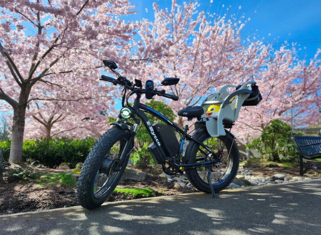 Electric bike parked under blooming cherry blossoms, vibrant spring scene in the USA.